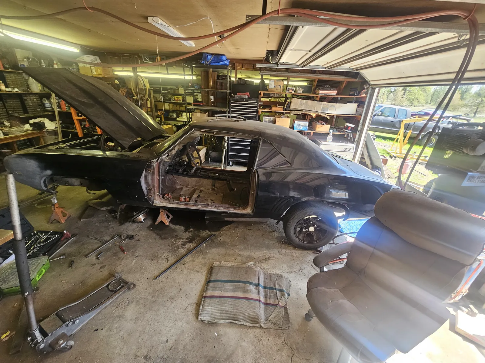 Black Pontiac stripped down in a garage during a driveline project