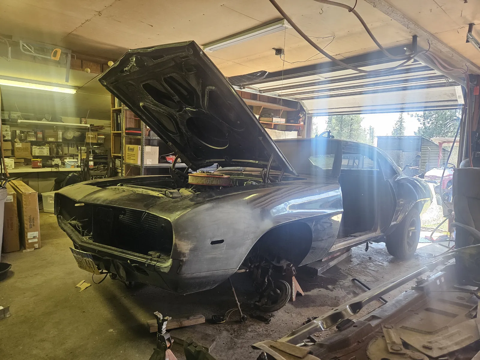 Muscle car with the hood raised while brakes and suspension are inspected