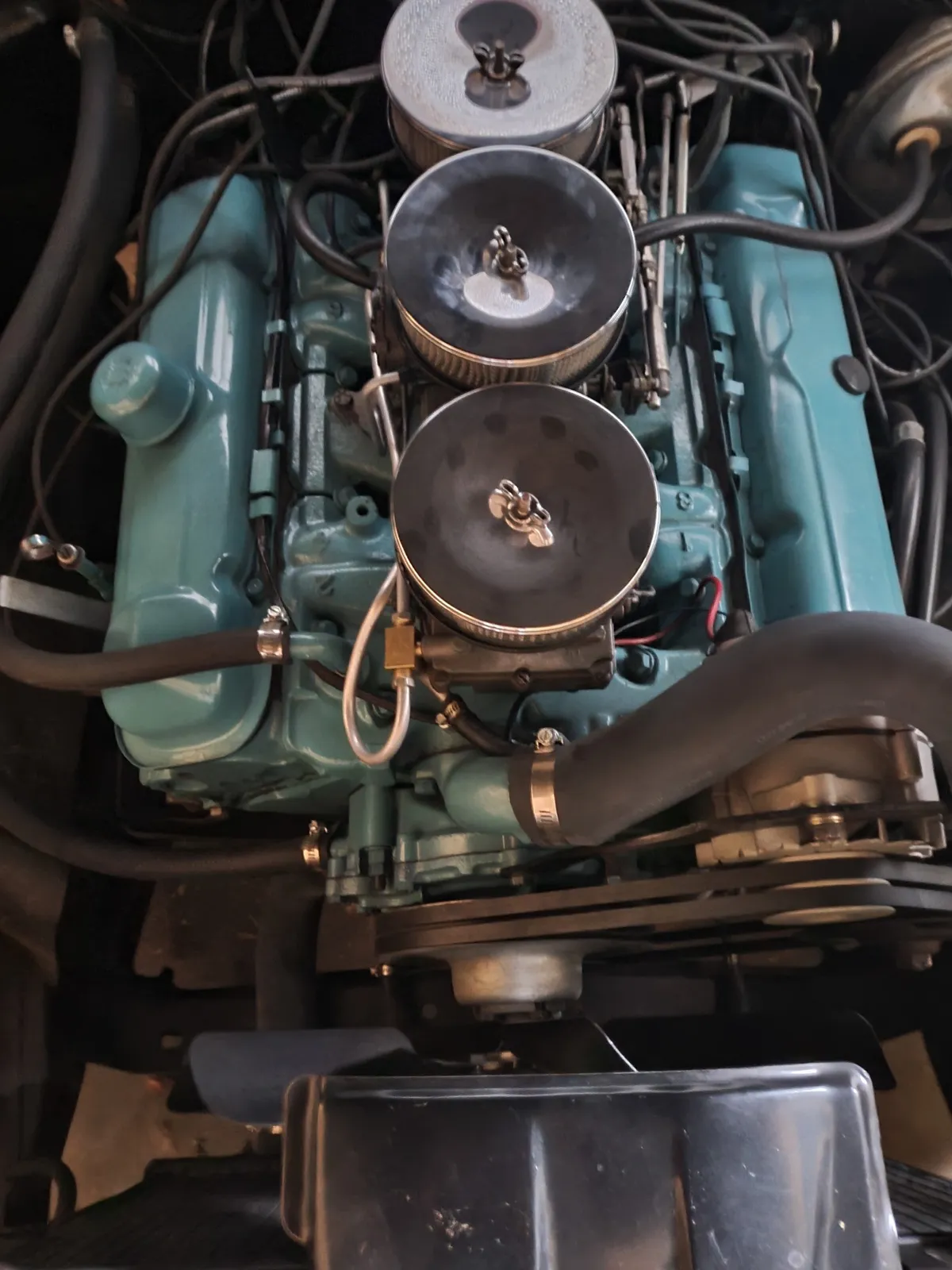Vintage inline engine bay with dual carburetors during a tune up