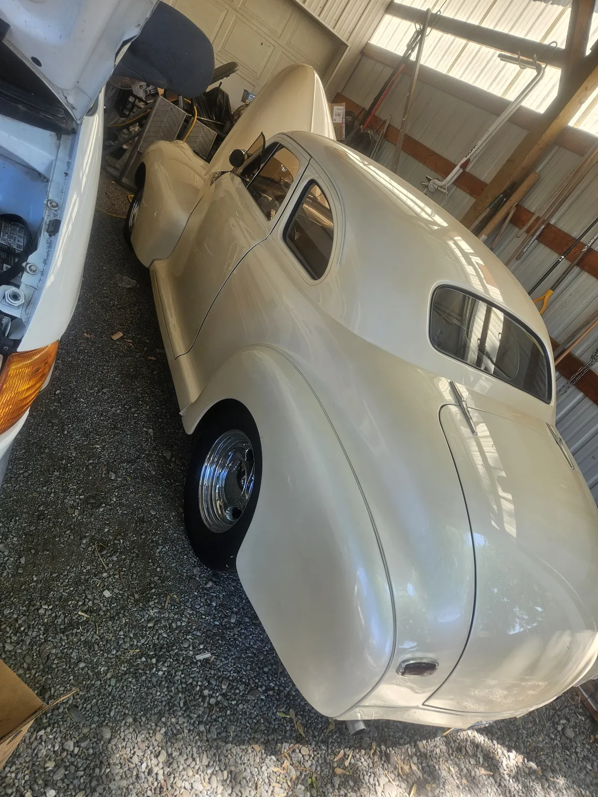 1941 Chevrolet Special Deluxe body in primer parked on gravel beside a shop