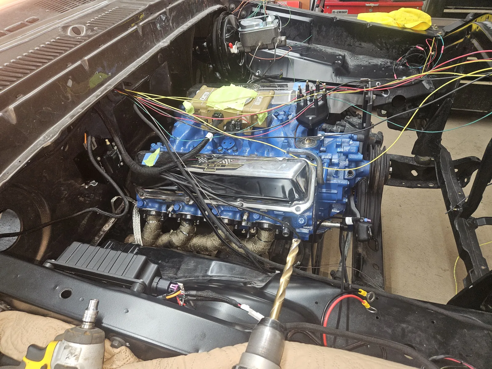 Close-up of a blue V8 engine and new wiring harness in a classic car