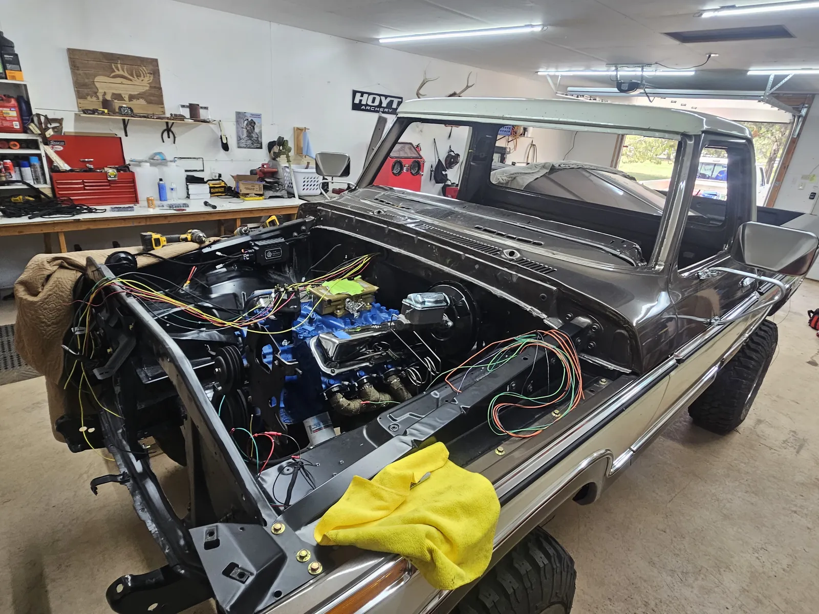 Truck engine bay with a rebuilt blue engine and fresh wiring